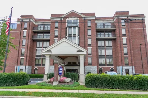 Large red brick building with a gazebo in front