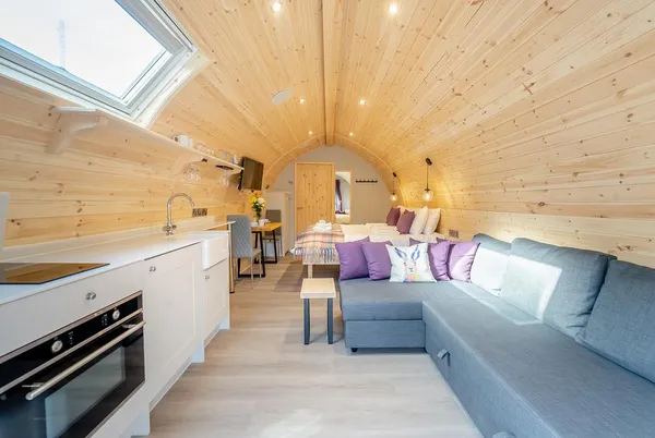 Hare glamping pod interior with sofa, kitchenette and bed
