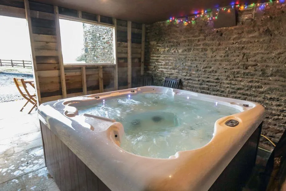 Hawthorn Cottage barn hot tub with fairy lights and window overlooking fields