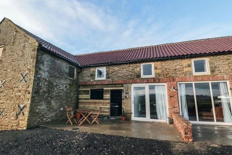 Hawthorn Cottage stone barn exterior with patio and glass doors