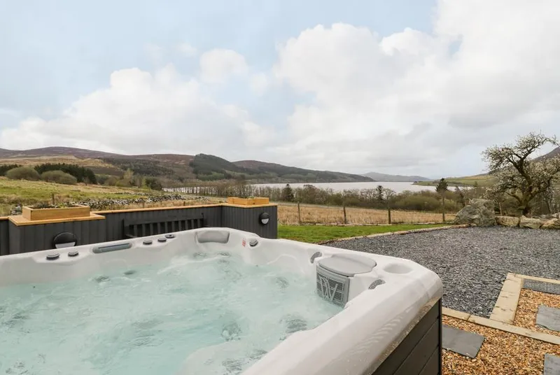 Hen Dy Craig Yr Ronwy hot tub overlooking lake and mountain scenery