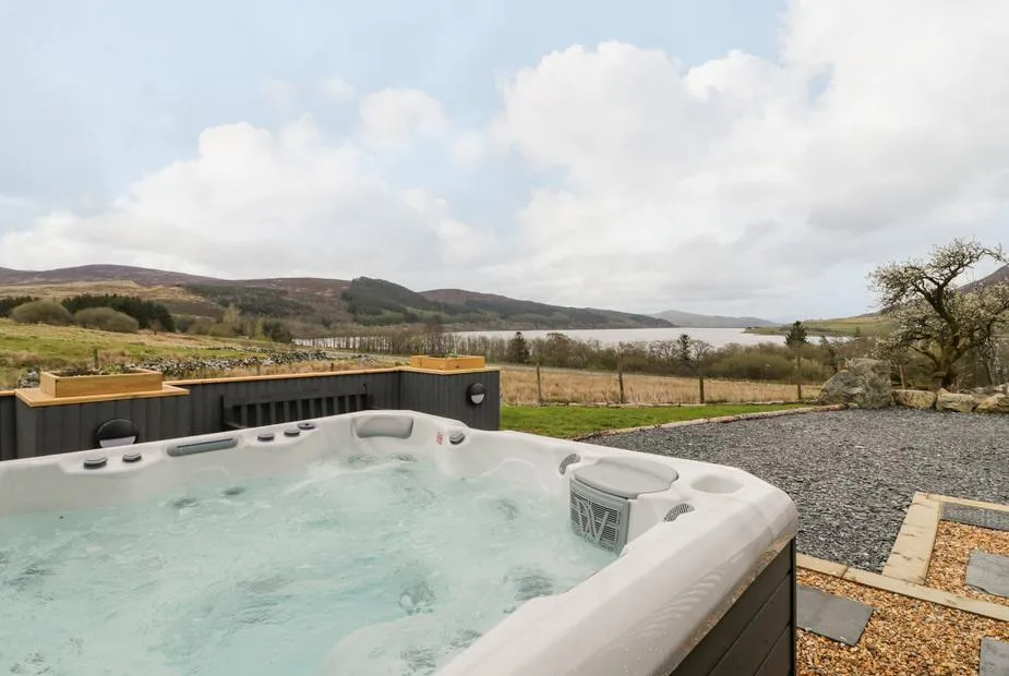 Hen Dy Craig Yr Ronwy hot tub overlooking lake and mountain scenery