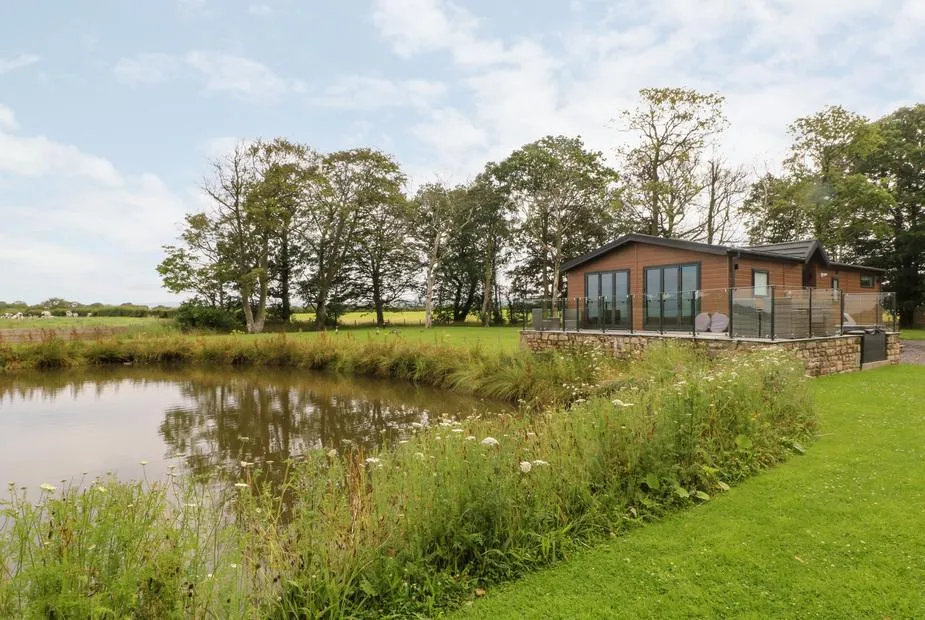 Henry Haven lodge by the lakeside with trees reflected in the water