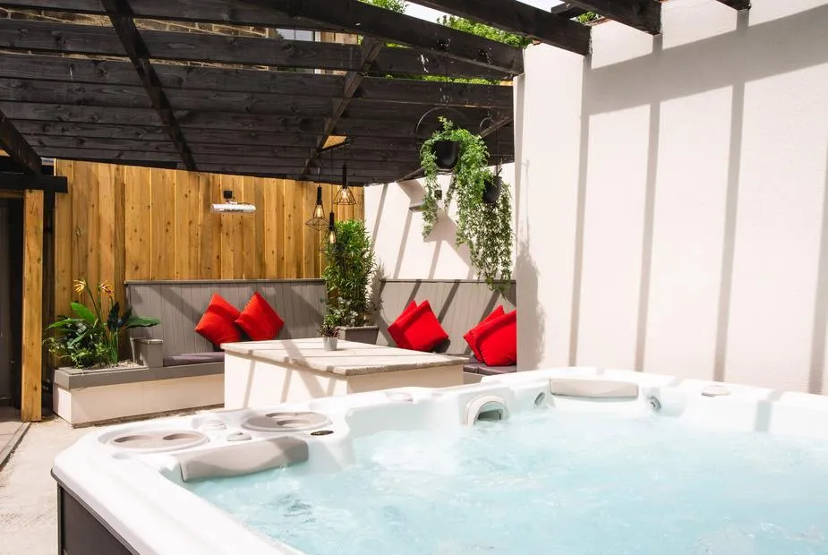 Herriots House hot tub with jets under pergola with hanging plants