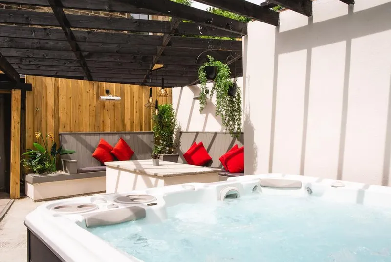 Herriots House hot tub with jets under pergola with hanging plants