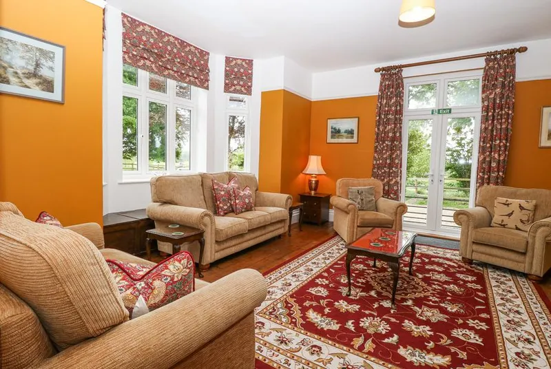 High House warm living room with multiple sofas and garden views