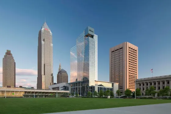 Glass Hilton tower behind a green lawn and walkway