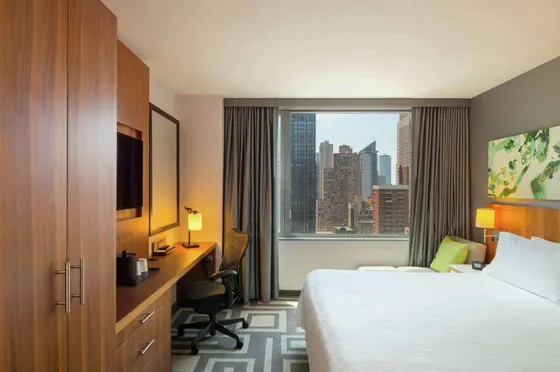 Hotel room with a bed and a desk and a window