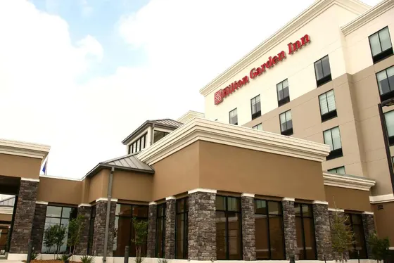 Tan hotel with stone columns and a Hilton Garden Inn sign