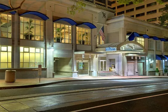 Hilton building at night with a street in front