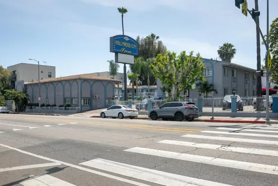Empty street with cars parked in front of a building