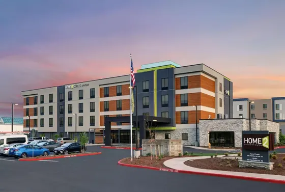 Rendering of a hotel with cars parked in a parking lot