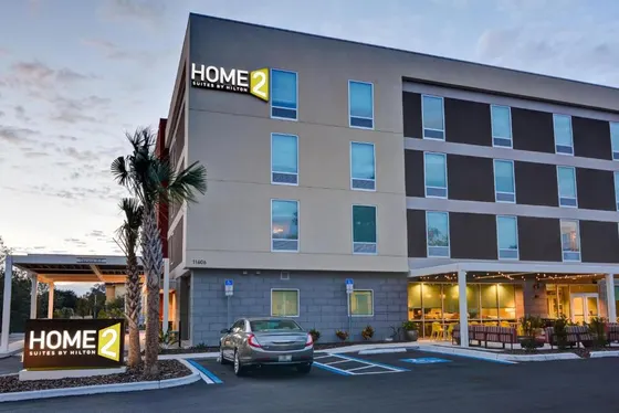 Hotel with a car parked in a parking lot