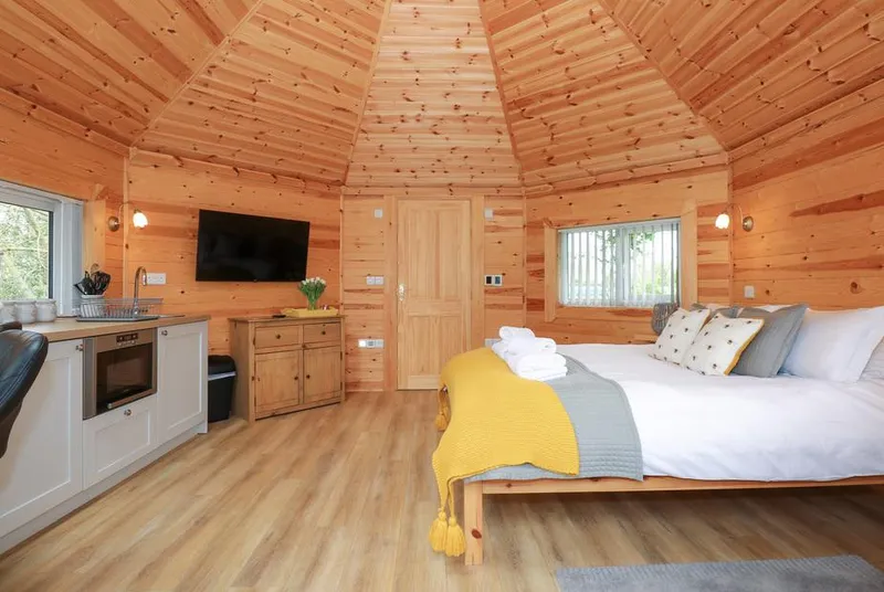 Honeybee Retreat full pod interior with king bed and vaulted pine ceiling