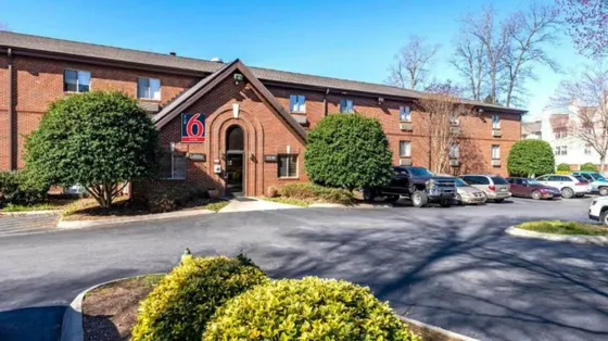 Large brick building with cars parked in front of it