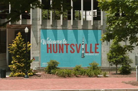 Welcome to Huntsville Rocket City mural framed by trees and shrubs