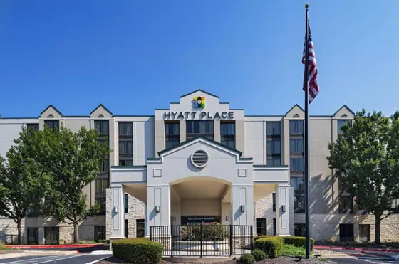 Hyatt Place exterior with a white arched canopy and flag