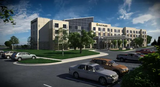 Tan Hyatt Place hotel with a covered driveway and parking lot