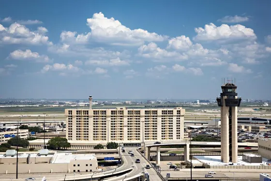 Tan hotel beside an airport control tower
