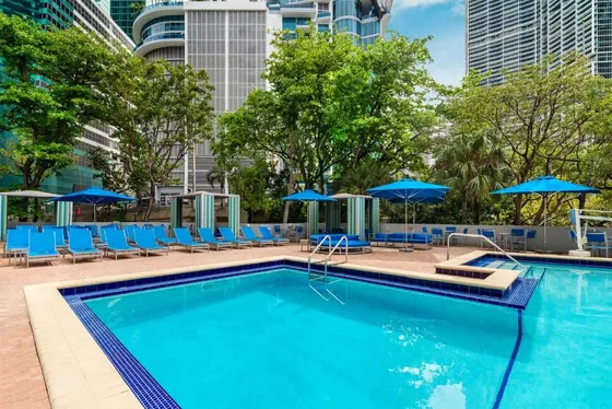 Swimming pool with blue chairs and umbrellas