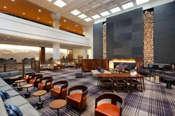 Lounge with a stone fireplace and orange chairs