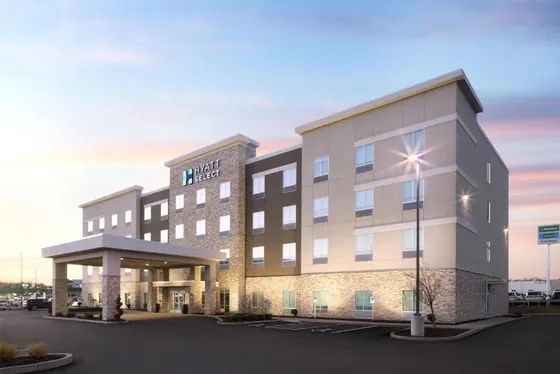 Rendering of a hotel building with a parking lot