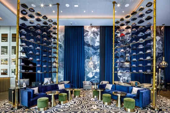 Lobby with blue chairs and a wall of wine bottles