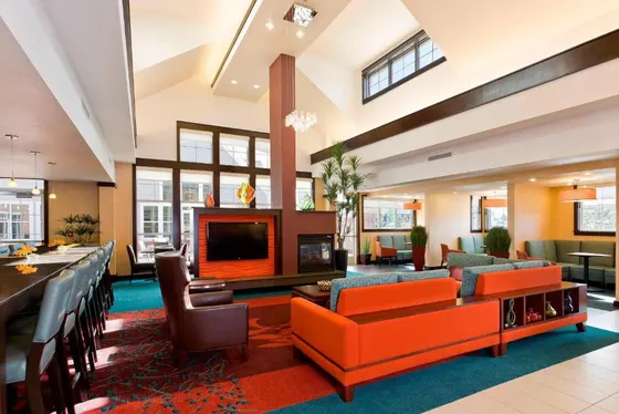 Lobby with orange couches and a fireplace