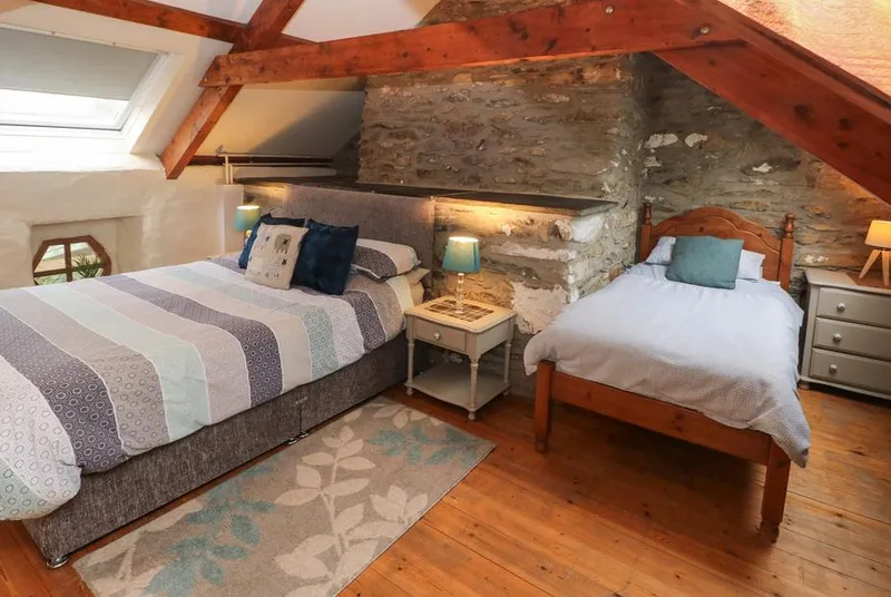 Ty Llwyd attic family bedroom with exposed stone chimney breast