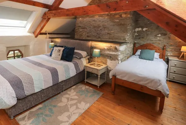 Ty Llwyd attic family bedroom with exposed stone chimney breast