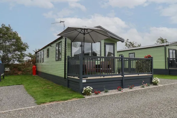 Jean's Place lodge front with wraparound deck and parasol