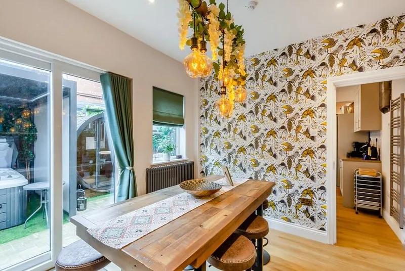 Jorvik Villas dining area with botanical wallpaper and glass courtyard doors