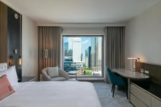 Hotel room with a bed and a desk and a window