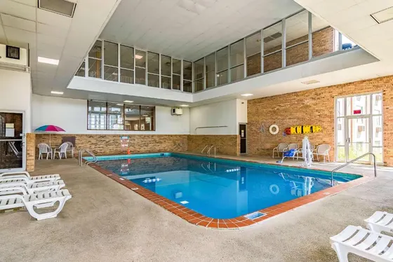 Large swimming pool with white chairs and a pool