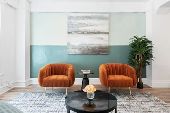 Two orange chairs and a table in a living room