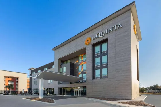 Gray hotel with a white canopy and an orange La Quinta sign