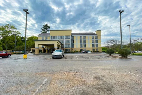 Large yellow building with a car parked in a parking lot