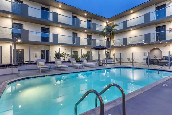Swimming pool in a hotel with chairs and a building