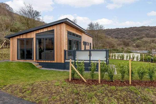 Langford Premier cedar-clad lodge with landscaped garden and green hills