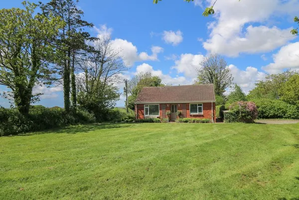 Lavender Lodge red-brick bungalow beyond a broad lawn
