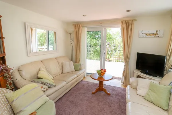 Lavender Lodge bright lounge with patio doors and cream seating