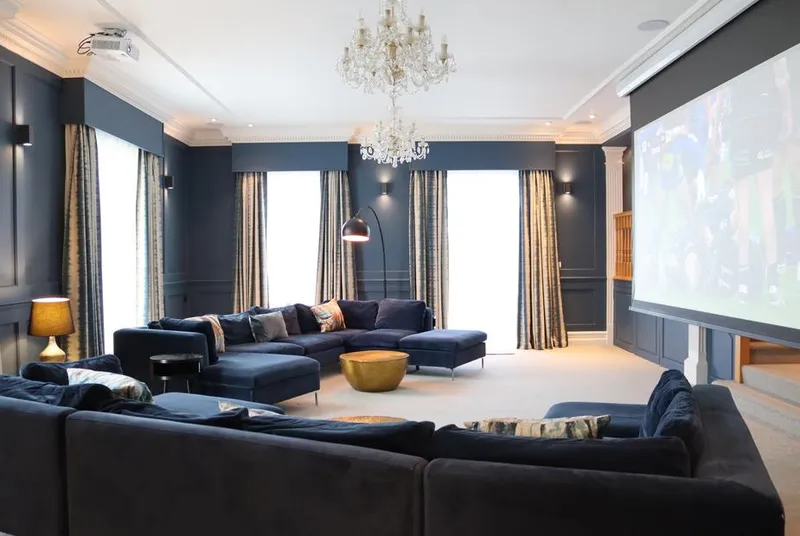 Leafield House cinema room with navy velvet sofas and crystal chandelier