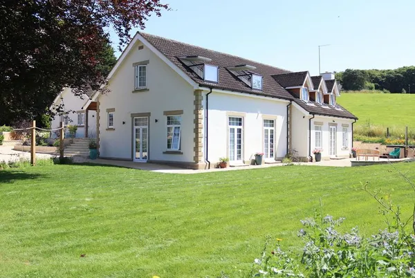 Leafield House rear view from lawn with rolling Wiltshire countryside