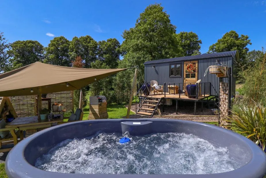 Limetree Luxury Glamping Portland hot tub and shepherd's hut beside canopy seating