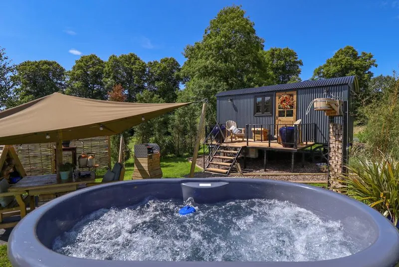 Limetree Luxury Glamping Portland hot tub and shepherd's hut beside canopy seating