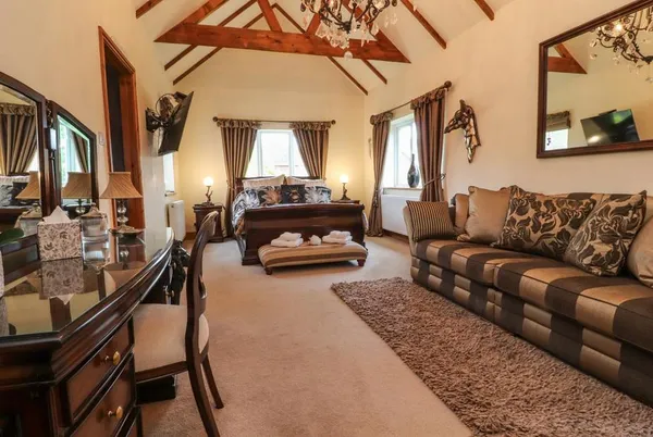 Linwood vaulted bedroom with a sofa and wooden bed