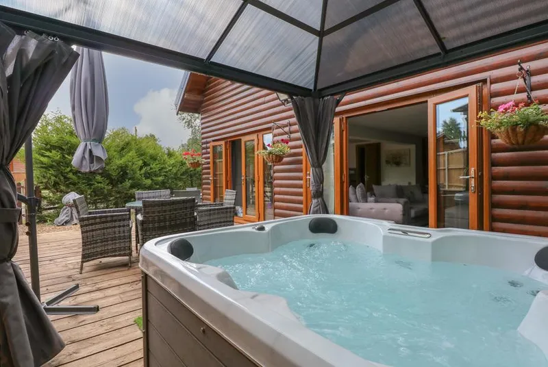 Little Lodge hot tub under gazebo with blue sky