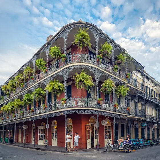 Brick corner building with iron balconies and ferns
