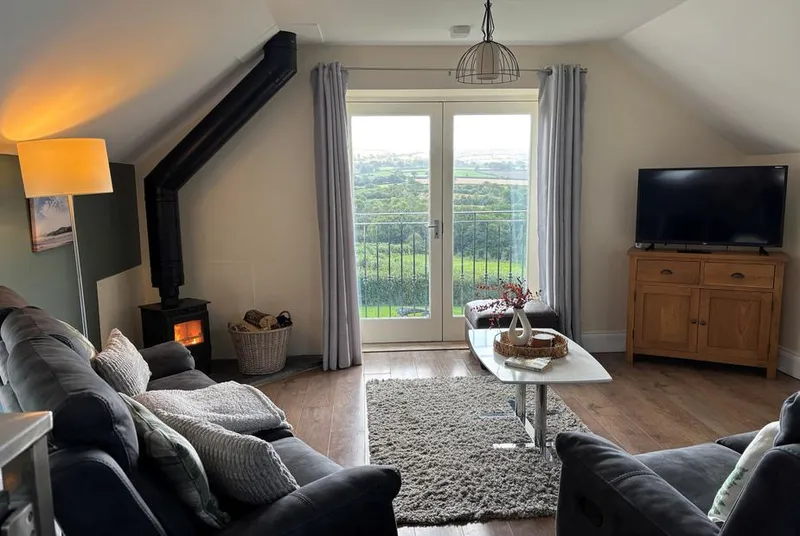 Ysgubor The Barn lounge with log burner and valley-view doors