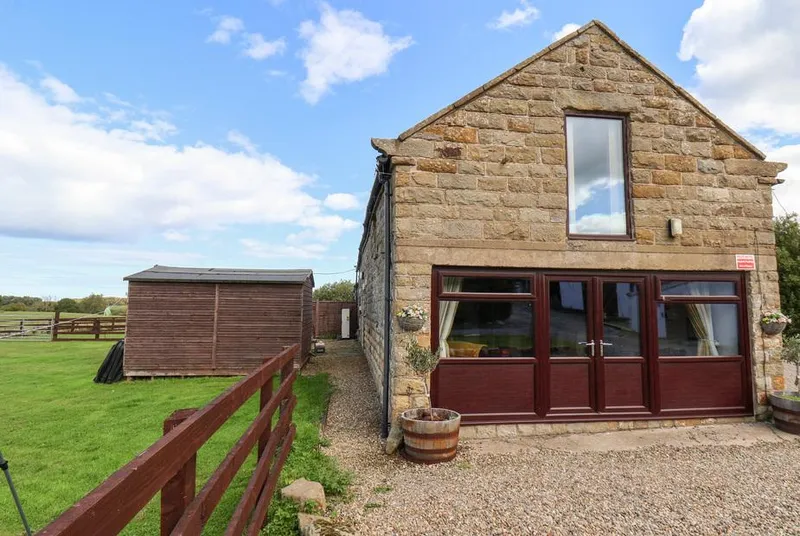 Hayloft stone barn exterior with garden and countryside setting